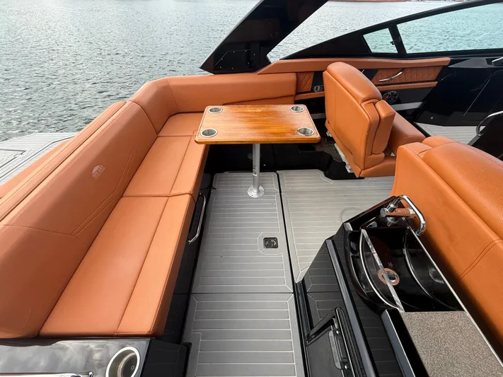  Yacht Photos Pics 2022 Cruisers Yachts 338 CX SB interior with tan seating and wooden table, overlooking water.