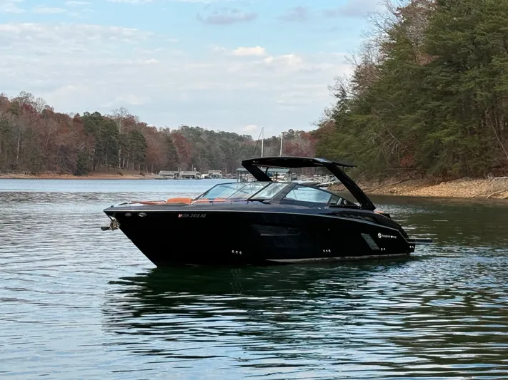  Yacht Photos Pics 2022 Cruisers Yachts 338 CX SB on a serene lake with forested shoreline.