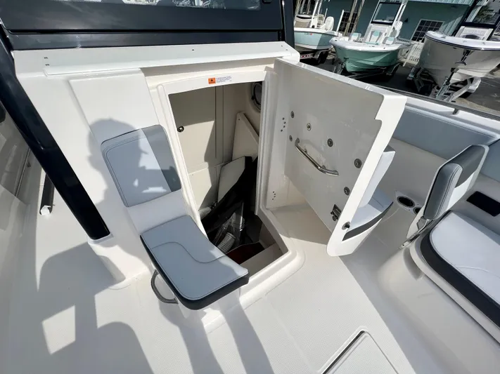  Yacht Photos Pics 2025 Robalo R300 boat interior with open storage compartment and seating area.