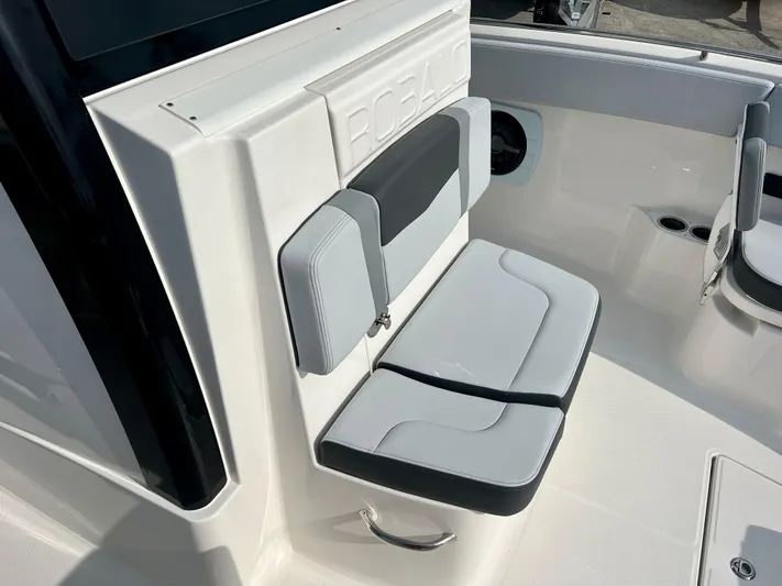  Yacht Photos Pics 2025 Robalo R300 boat interior with cushioned seating and sleek design.