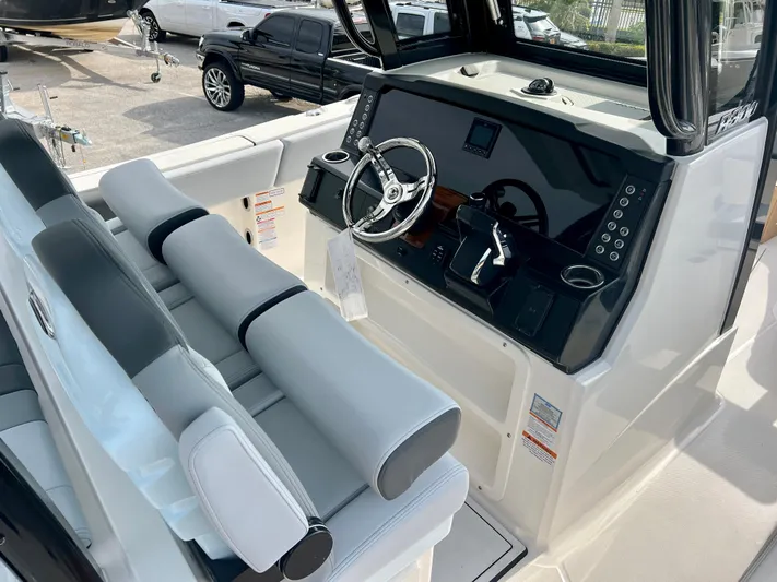  Yacht Photos Pics 2025 Robalo R300 boat cockpit with modern steering and seating.