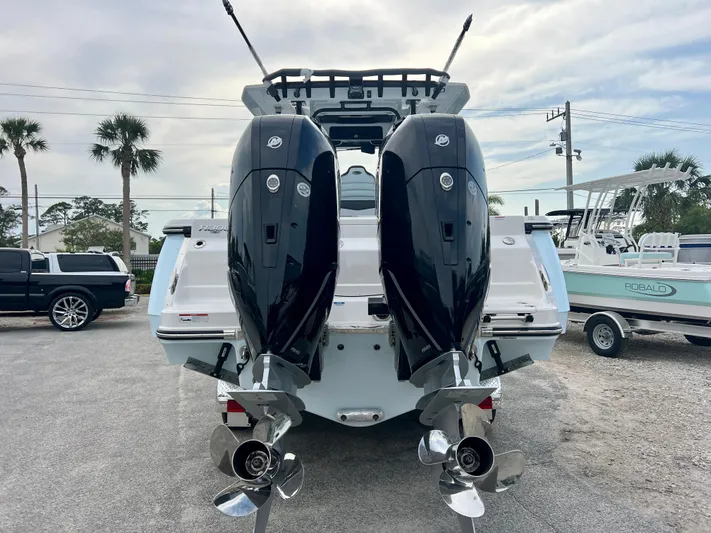  Yacht Photos Pics 2025 Robalo R300 boat with dual outboard engines, parked in a marina.