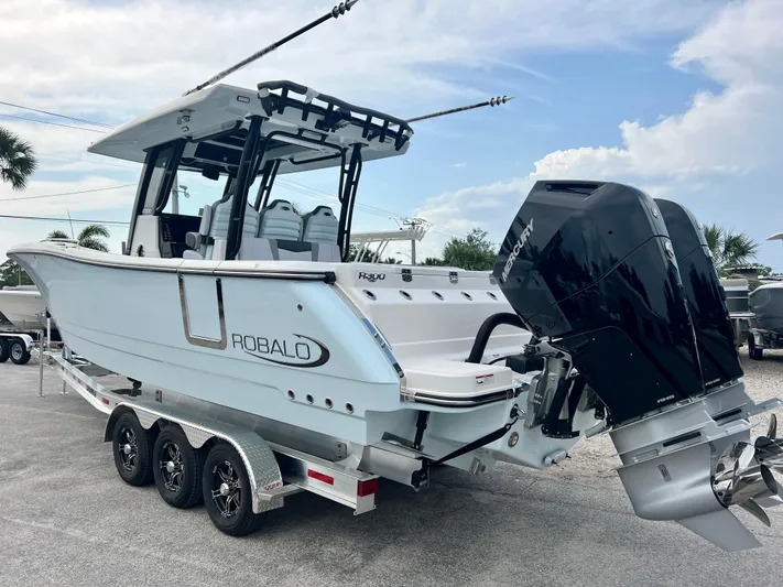  Yacht Photos Pics 2025 Robalo R300 boat on trailer, featuring dual outboard engines.