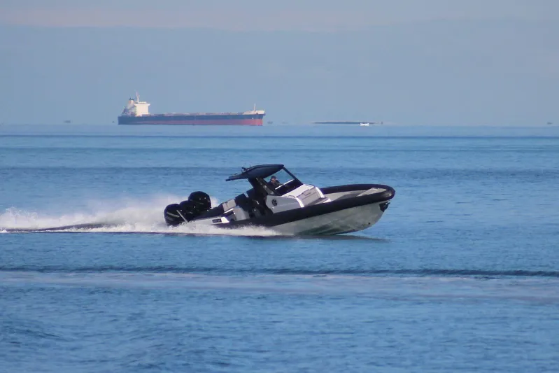 Yacht Photos Pics 2026 Northstar ION 12 speedboat cruising on open water with cargo ship in background.