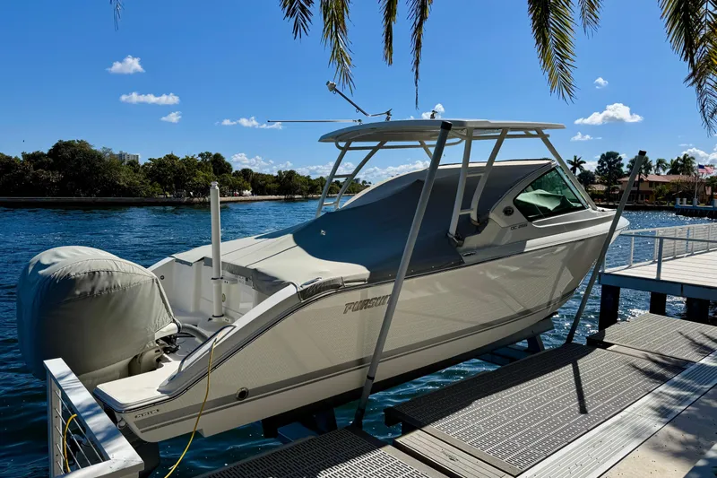  Yacht Photos Pics 2020 Pursuit DC 266 Dual Console boat docked by a scenic waterfront.