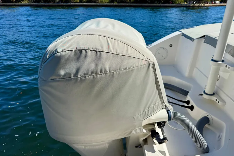  Yacht Photos Pics 2020 Pursuit DC 266 Dual Console boat engine covered, docked on calm water.