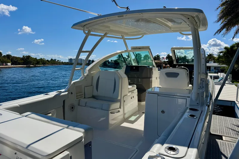  Yacht Photos Pics 2020 Pursuit DC 266 Dual Console boat docked by a scenic waterfront.