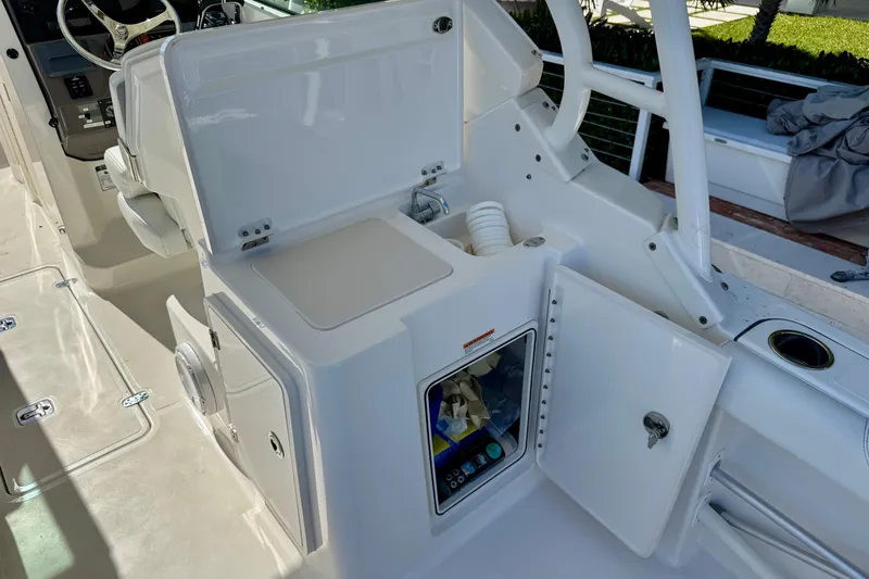  Yacht Photos Pics 2020 Pursuit DC 266 Dual Console boat interior with open storage compartments and steering wheel.