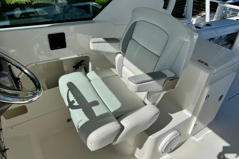  Yacht Photos Pics 2020 Pursuit DC 266 Dual Console boat interior with plush captain's chair and steering wheel.