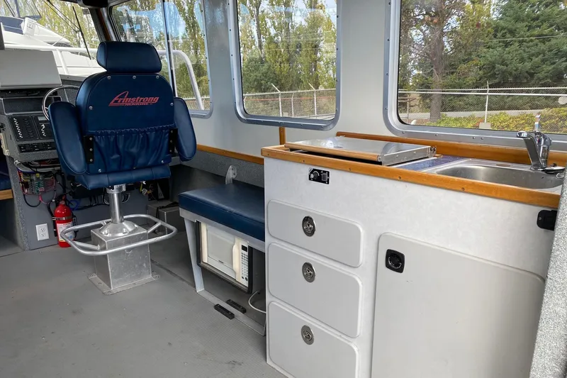 Apollo Axon Yacht Photos Pics 2007 Armstrong Marine Catamaran interior with captain's chair, sink, and storage drawers.