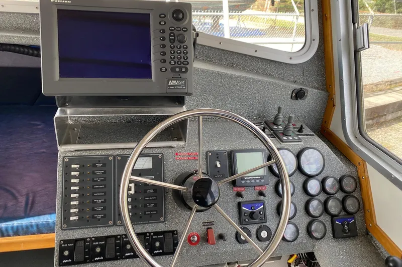 Apollo Axon Yacht Photos Pics Control panel of a 2007 Armstrong Marine Catamaran with steering wheel and navigation equipment.