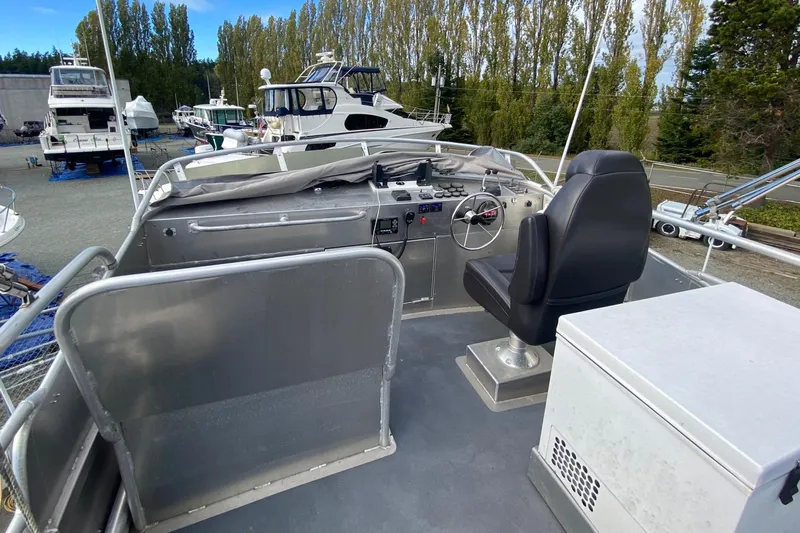 Apollo Axon Yacht Photos Pics 2007 Armstrong Marine Catamaran with open deck and captain's chair, docked among trees and boats.