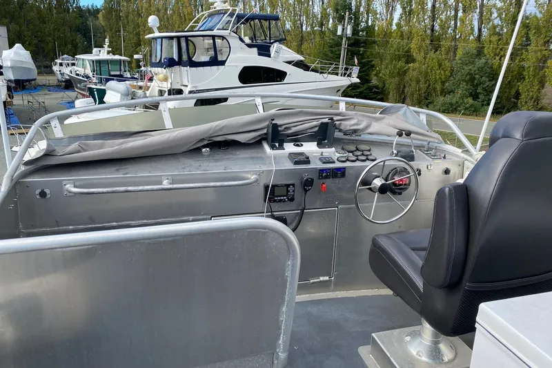 Apollo Axon Yacht Photos Pics 2007 Armstrong Marine Catamaran helm with steering wheel and controls, docked near other boats.