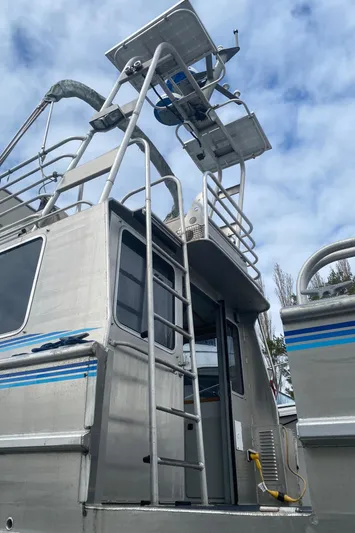 Apollo Axon Yacht Photos Pics 2007 Armstrong Marine Catamaran with ladder and upper deck against cloudy sky.