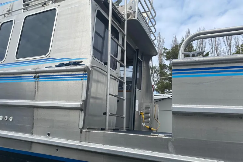 Apollo Axon Yacht Photos Pics Armstrong Marine 2007 Catamaran with aluminum exterior and blue accents, docked outdoors.