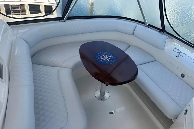  Yacht Photos Pics 2006 Sea Ray 580 Sedan Bridge interior with white seating and wooden table.