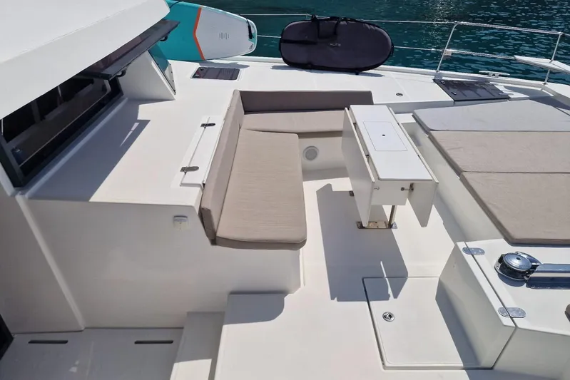 Only One Life Yacht Photos Pics 2022 Bali 5.4 Open Space yacht deck with seating and table, near turquoise water.