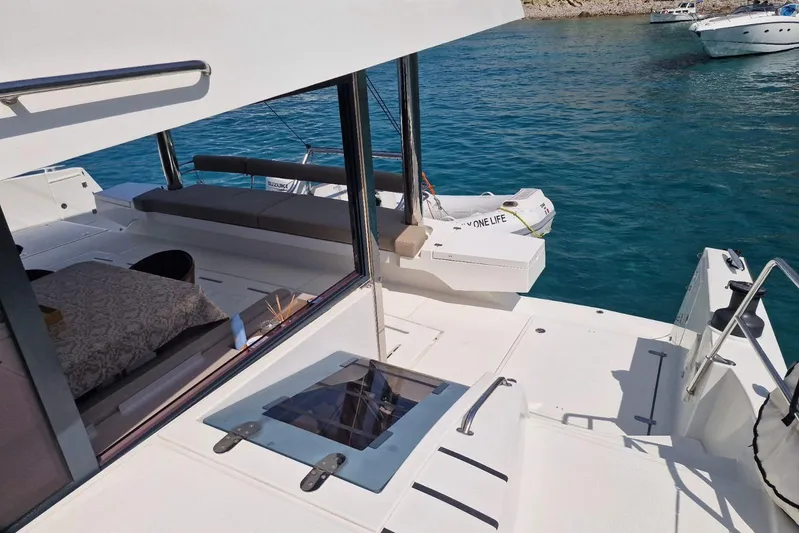 Only One Life Yacht Photos Pics 2022 Bali 5.4 Open Space yacht with spacious deck and seating, anchored in clear blue waters.