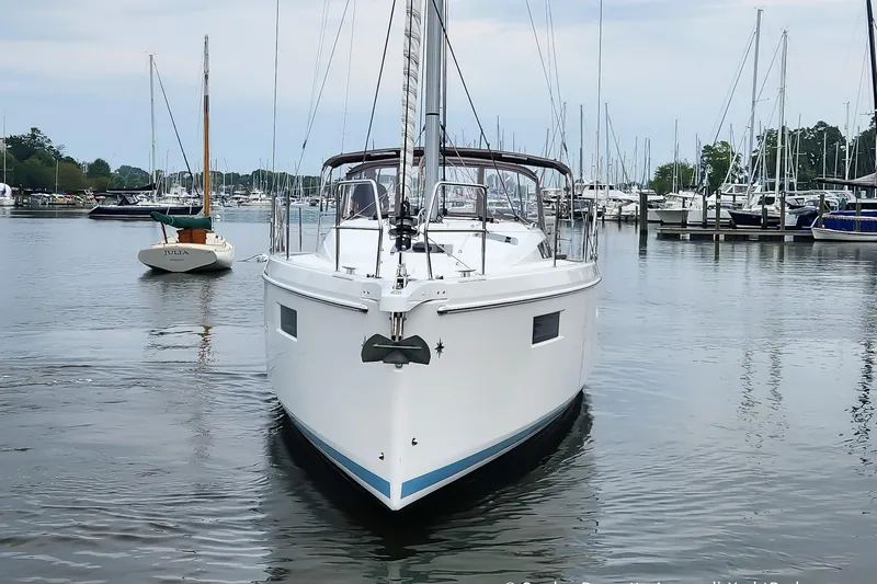 Shatzi Yacht Photos Pics 2022 Jeanneau Sun Odyssey 410 sailboat docked in a marina, surrounded by other boats.
