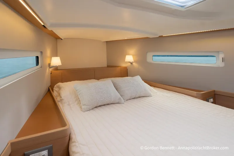 Shatzi Yacht Photos Pics Luxurious cabin interior of 2022 Jeanneau Sun Odyssey 410 yacht, featuring cozy bedding and ambient lighting.