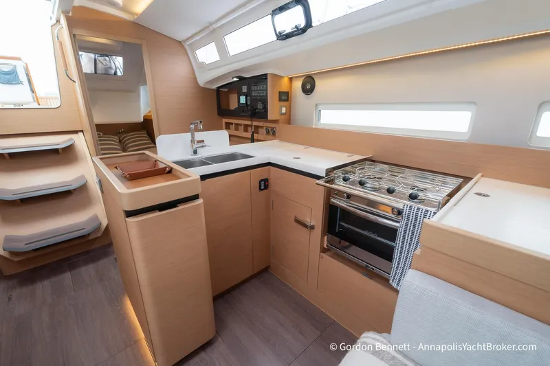 Shatzi Yacht Photos Pics Modern interior of 2022 Jeanneau Sun Odyssey 410 yacht, featuring sleek kitchen and cozy cabin.