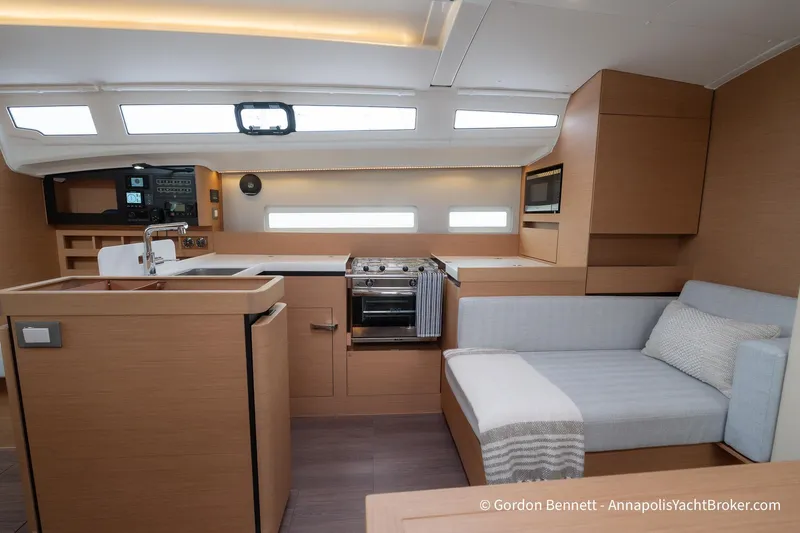 Shatzi Yacht Photos Pics Modern interior of 2022 Jeanneau Sun Odyssey 410 yacht with kitchen and seating area.