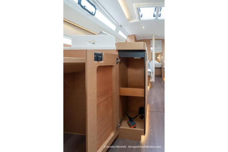 Shatzi Yacht Photos Pics Interior view of 2022 Jeanneau Sun Odyssey 410 yacht, featuring open wooden cabinetry.