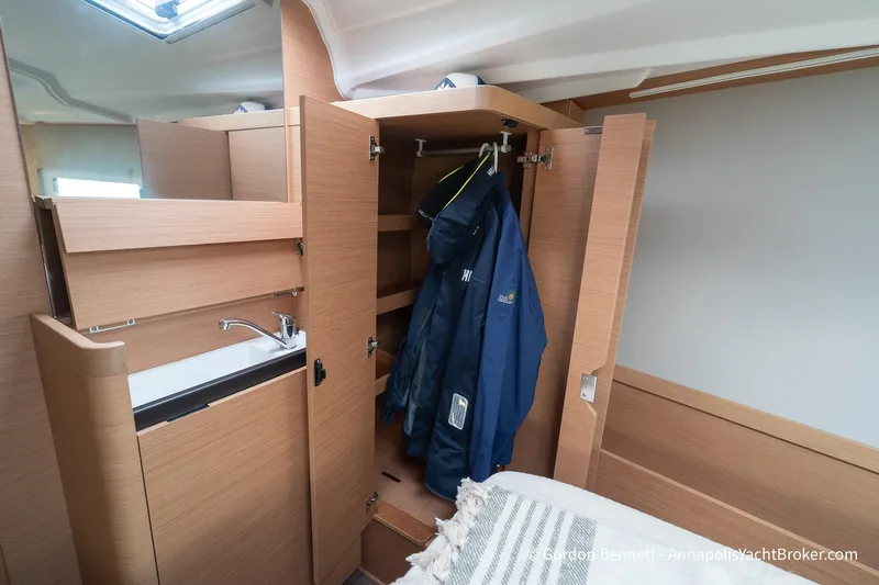 Shatzi Yacht Photos Pics Interior of 2022 Jeanneau Sun Odyssey 410 yacht with wooden cabinetry and hanging jackets.