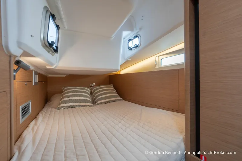 Shatzi Yacht Photos Pics Cozy cabin interior of 2022 Jeanneau Sun Odyssey 410 yacht with striped pillows.