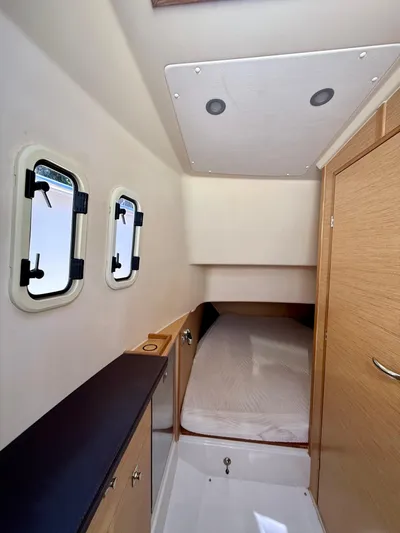  Yacht Photos Pics 2019 Fjord 36' Open cabin interior with bed, wooden cabinetry, and porthole windows.