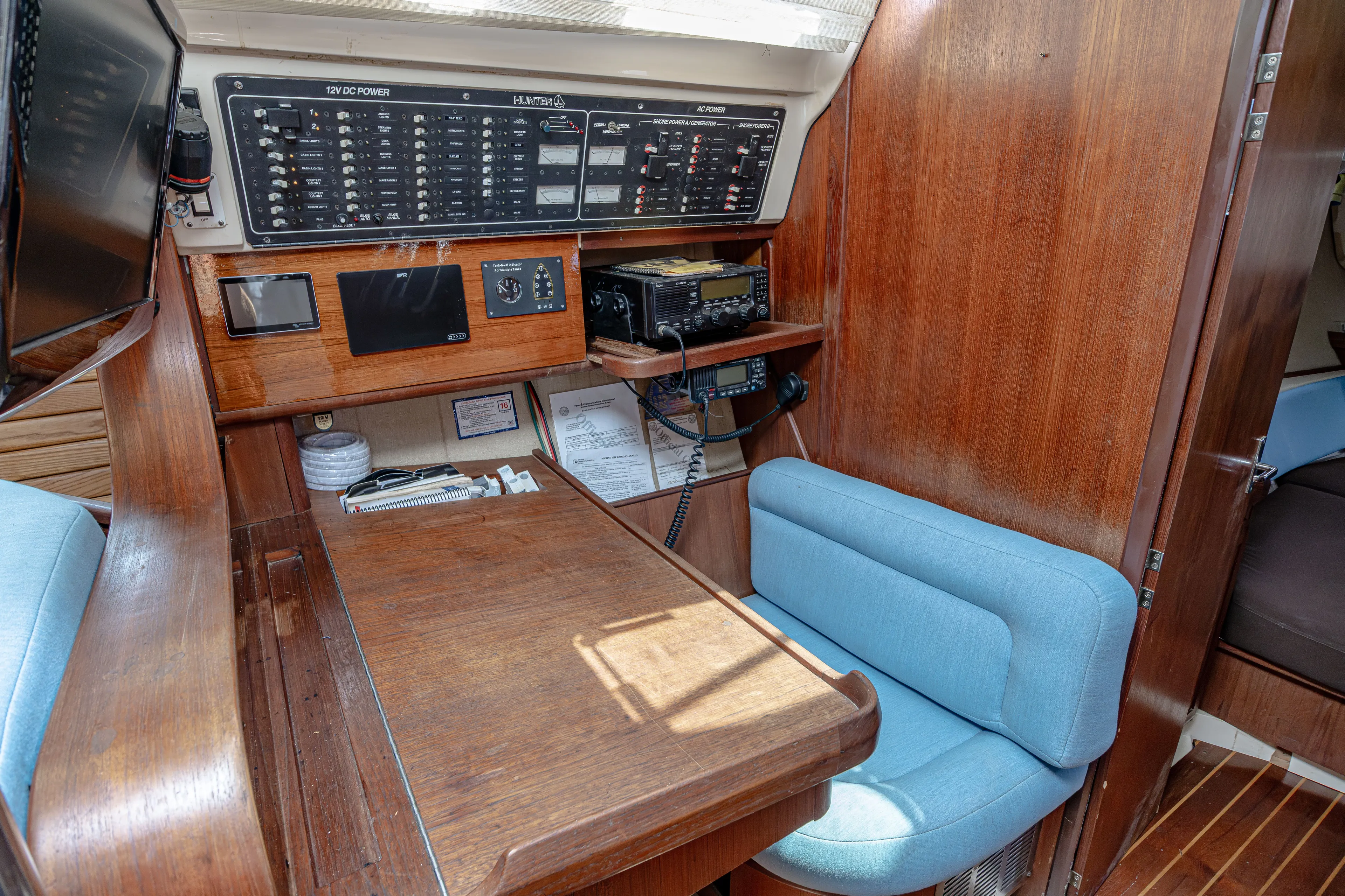 Into The Mystic Yacht Photos Pics Navigation station in a 1996 Hunter 430 sailboat with control panels and seating.