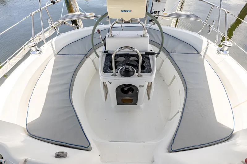 Into The Mystic Yacht Photos Pics Cockpit of a 1996 Hunter 430 sailboat with cushioned seating and steering wheel.