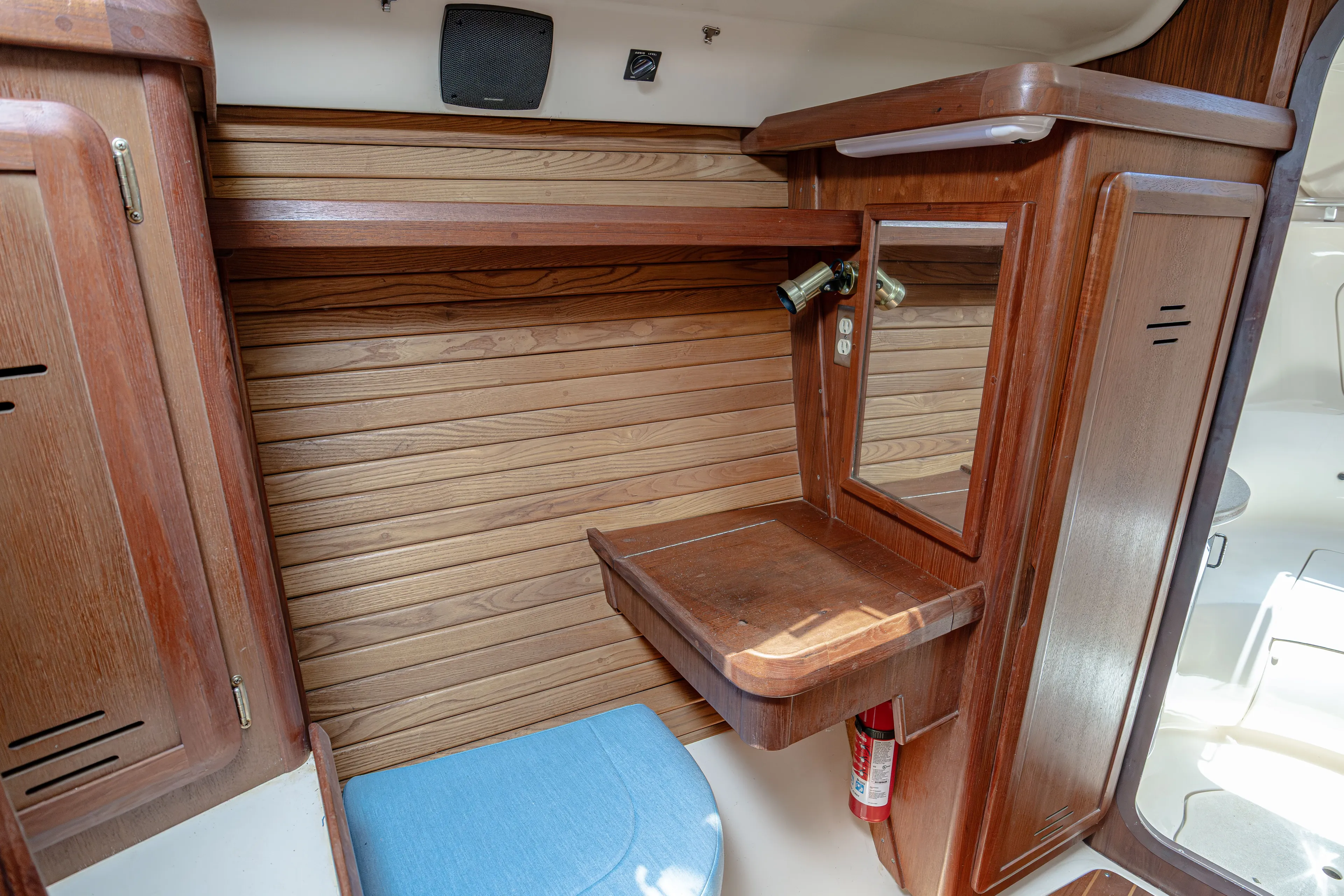 Into The Mystic Yacht Photos Pics Wooden interior of a 1996 Hunter 430 sailboat with a small desk and mirror.