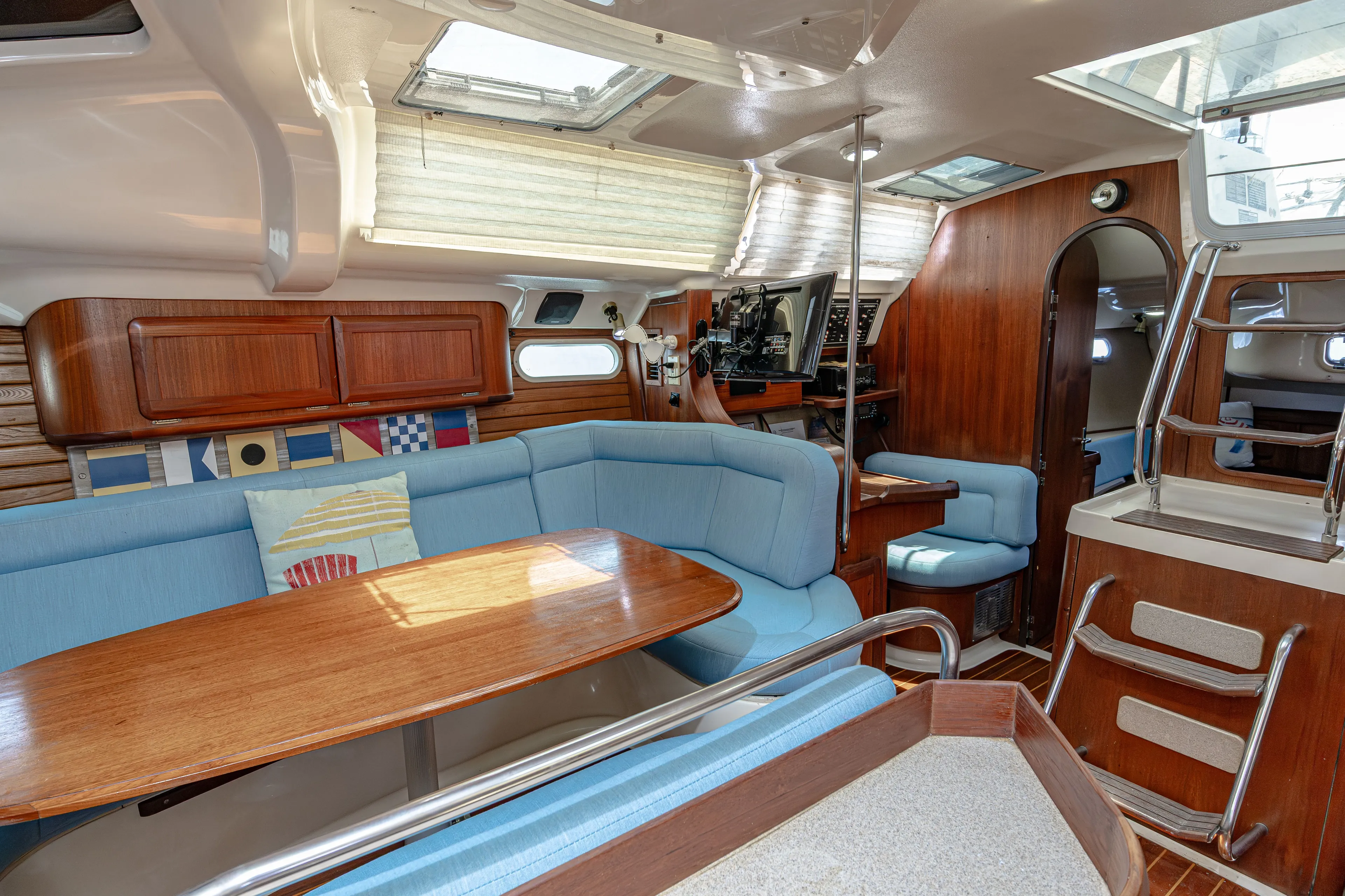 Into The Mystic Yacht Photos Pics Interior of a 1996 Hunter 430 sailboat with blue seating and wooden accents.