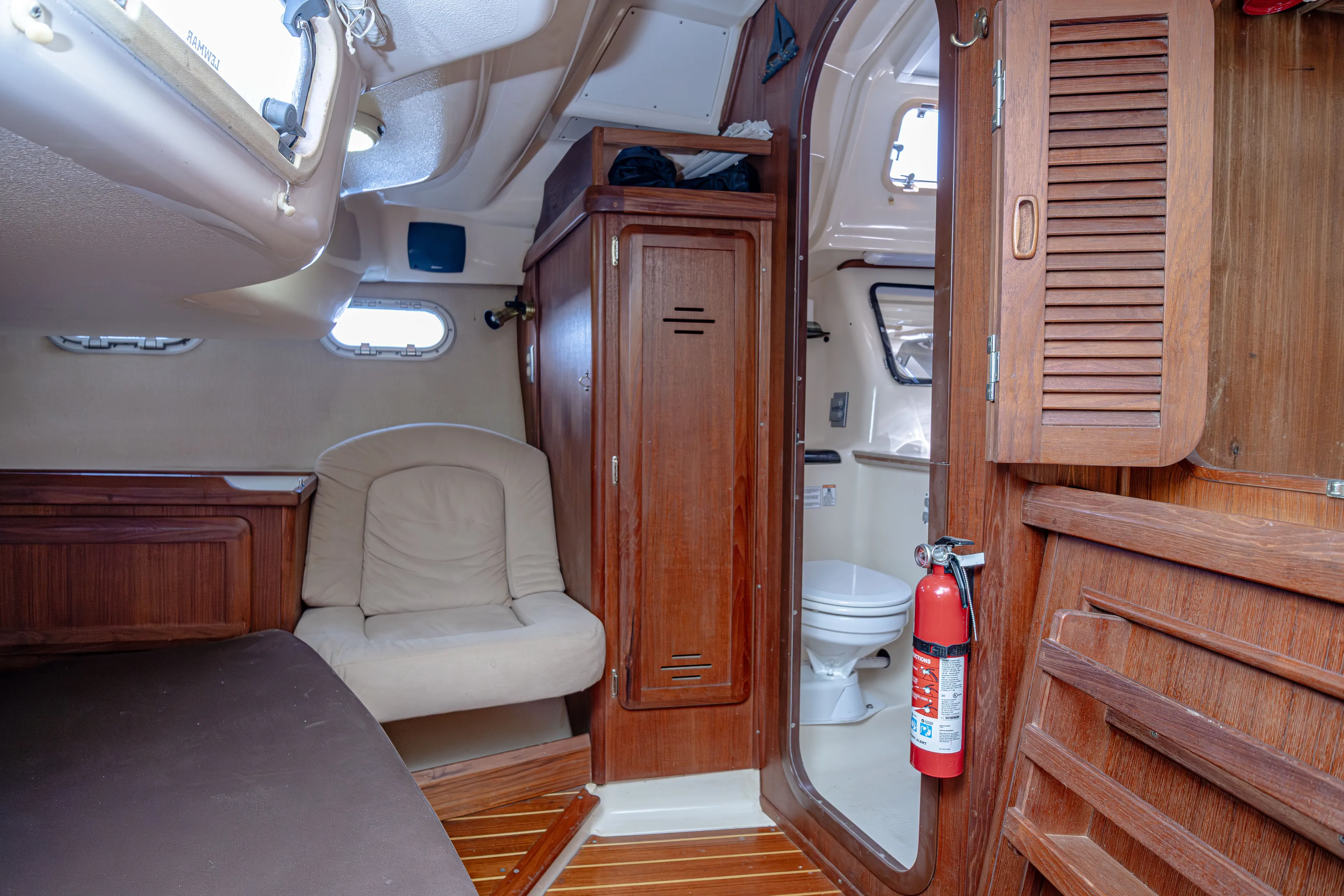 Into The Mystic Yacht Photos Pics Interior of a 1996 Hunter 430 sailboat featuring wood paneling and a compact bathroom.