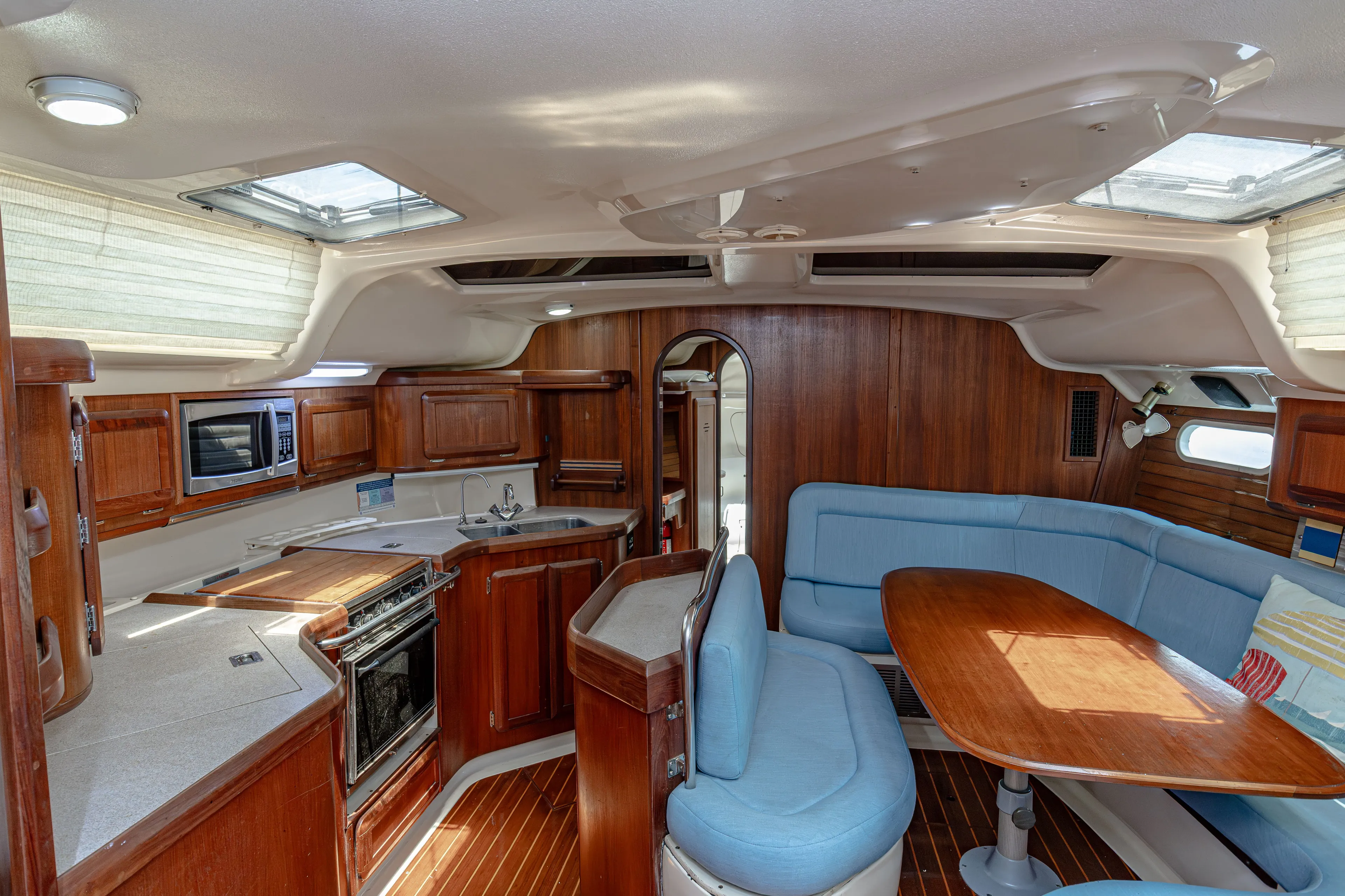 Into The Mystic Yacht Photos Pics Interior of 1996 Hunter 430 yacht with wood finish and blue seating.