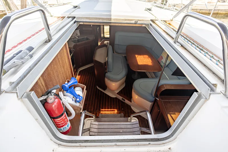 Into The Mystic Yacht Photos Pics Interior view of a 1996 Hunter 430 sailboat, featuring seating and a wooden table.