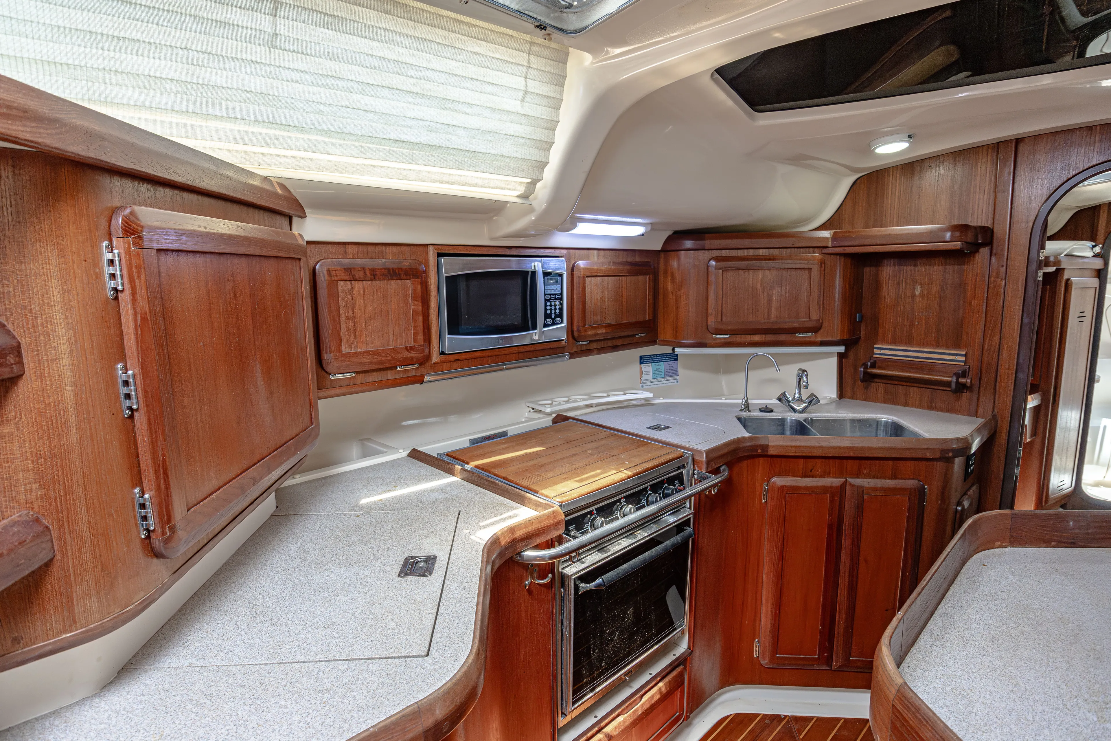 Into The Mystic Yacht Photos Pics Interior of a 1996 Hunter 430 yacht kitchen with wooden cabinets and modern appliances.