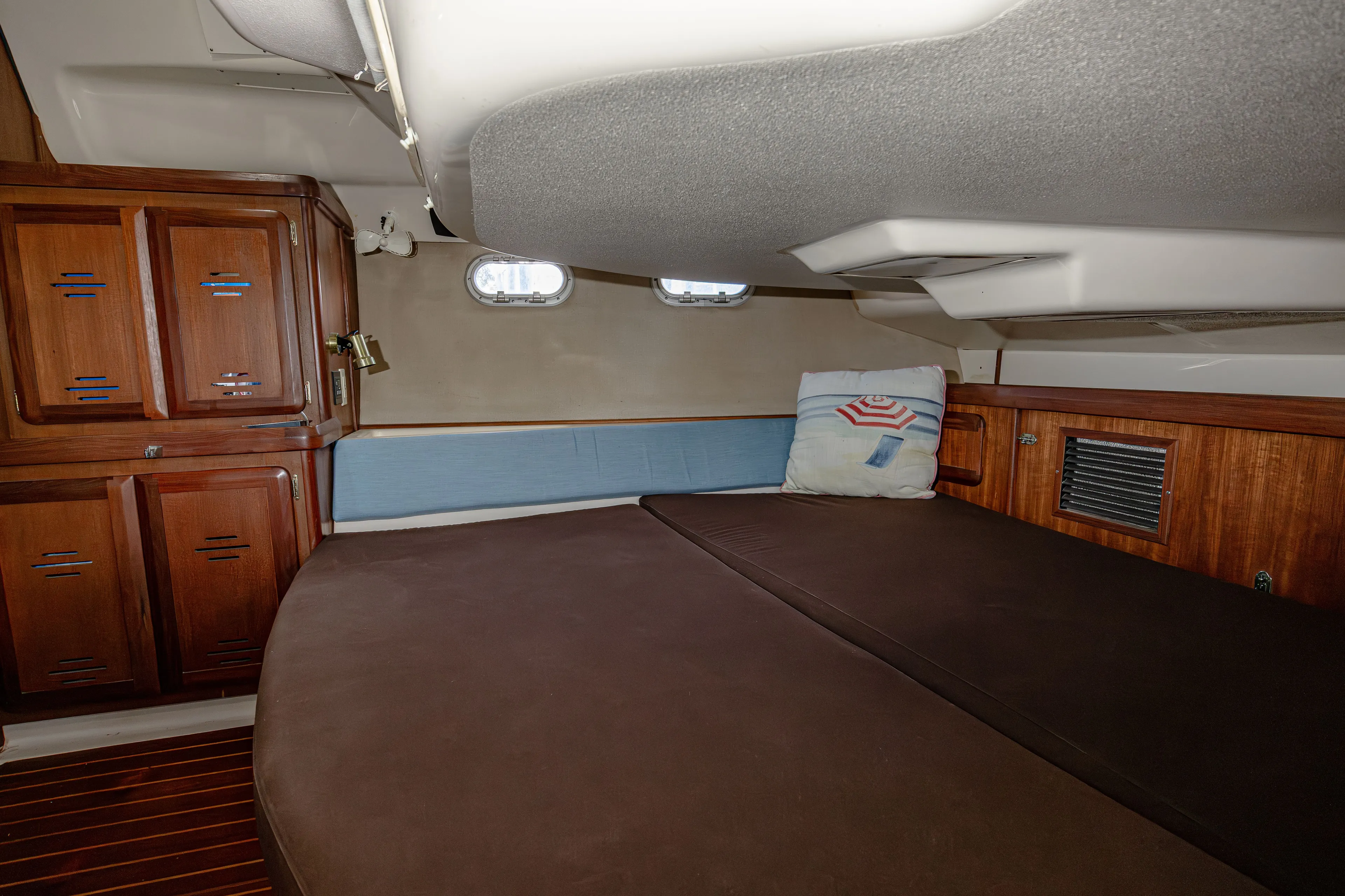 Into The Mystic Yacht Photos Pics Cozy cabin interior of 1996 Hunter 430 sailboat with wooden cabinets and cushioned seating.