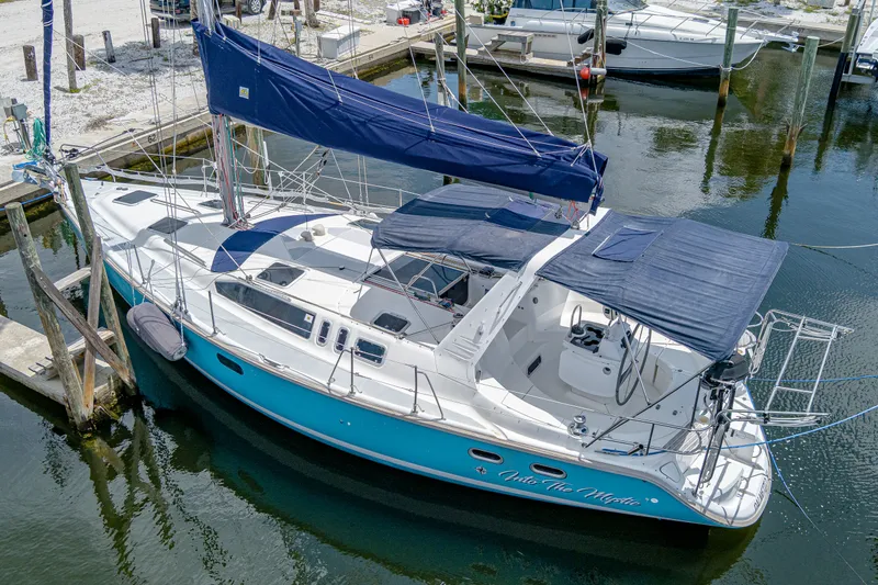 Into The Mystic Yacht Photos Pics Sailboat docked in marina, 1996 Hunter 430 model with blue hull and canopy.