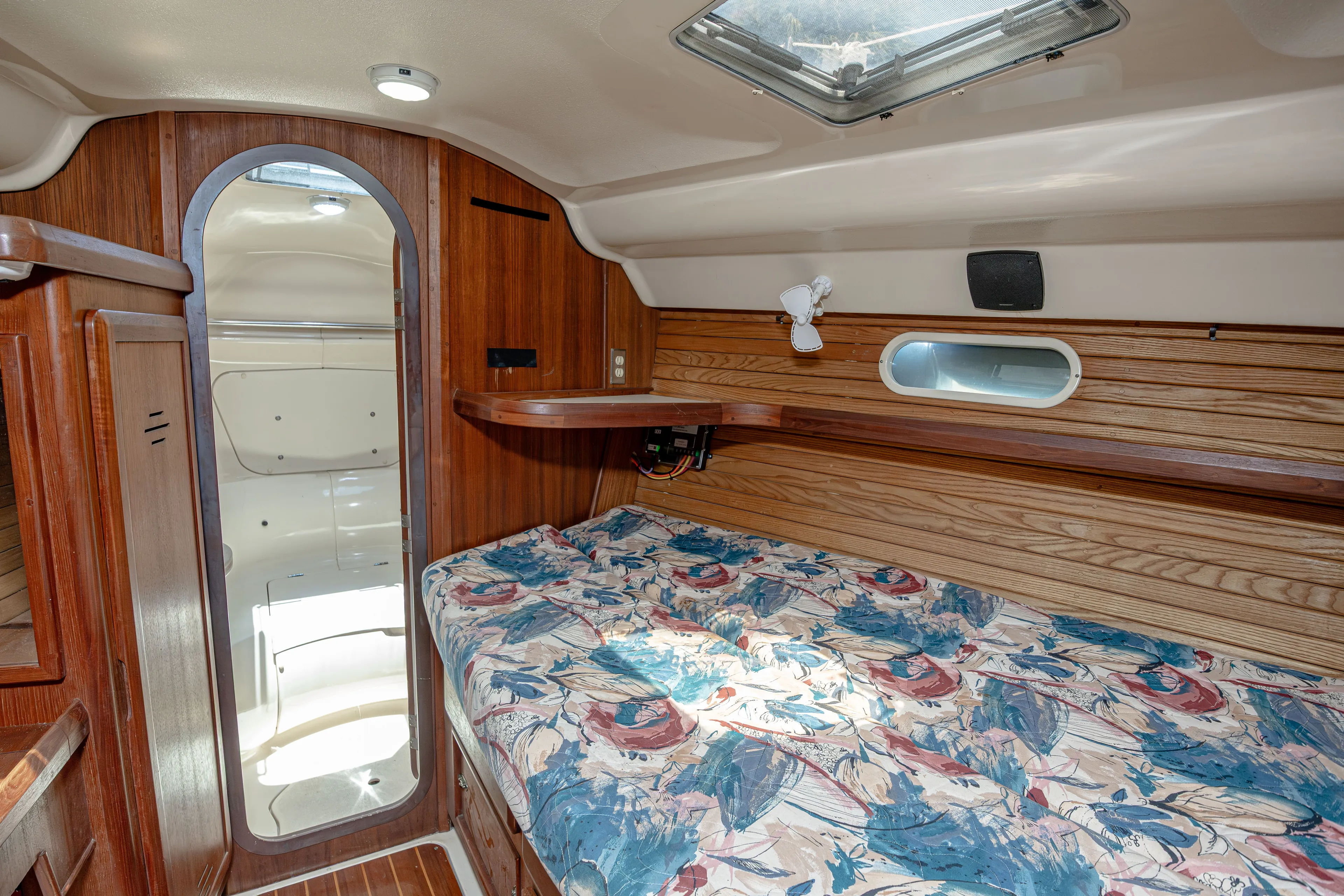 Into The Mystic Yacht Photos Pics Interior cabin of 1996 Hunter 430 sailboat with wood paneling and floral bedding.