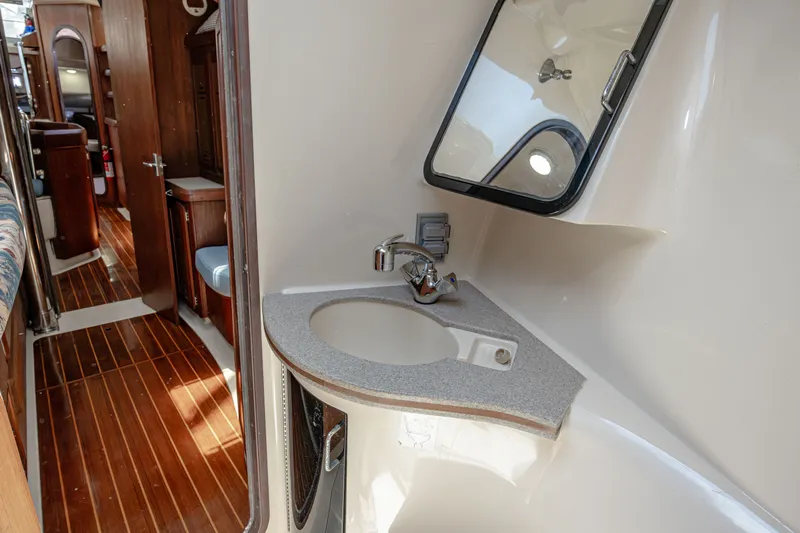 Into The Mystic Yacht Photos Pics Interior of 1996 Hunter 430 yacht showing bathroom sink and wooden flooring.