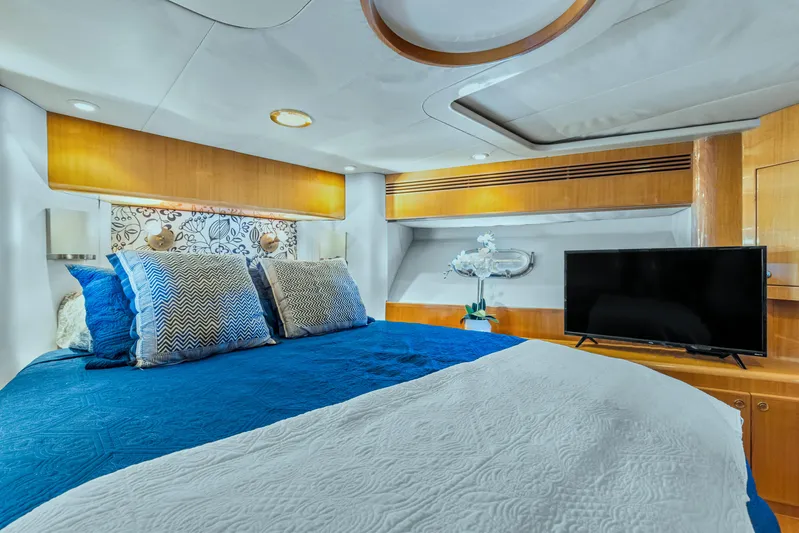  Yacht Photos Pics Luxurious bedroom in 2003 McKinna 58 Pilothouse yacht with modern decor and TV.