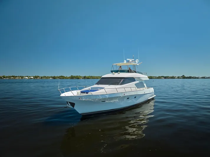  Yacht Photos Pics 2003 McKinna 58 Pilothouse yacht on calm water under clear blue sky.