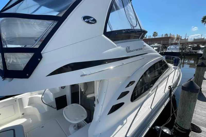 Beira Mar Yacht Photos Pics 2005 Sea Ray 420 Sedan Bridge yacht docked at marina under clear blue sky.