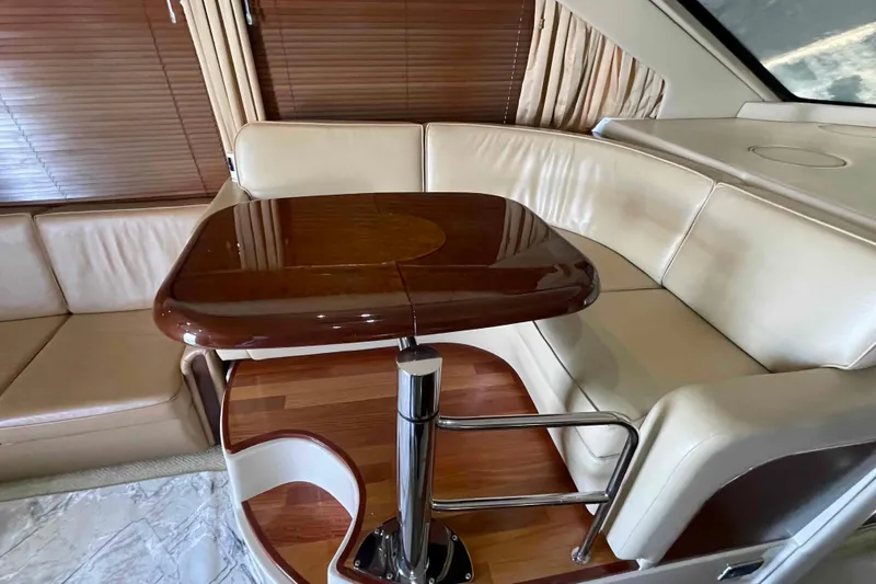 Beira Mar Yacht Photos Pics Luxurious interior of 2005 Sea Ray 420 Sedan Bridge with elegant seating and wooden table.