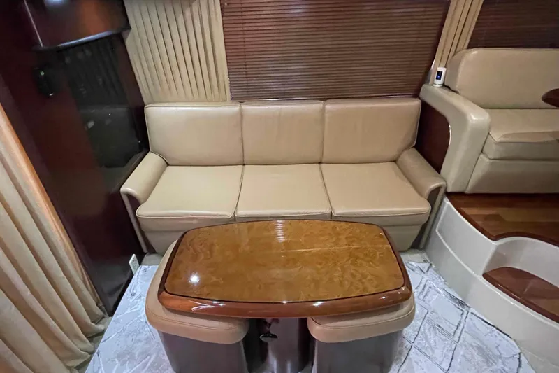 Beira Mar Yacht Photos Pics Luxurious interior of 2005 Sea Ray 420 Sedan Bridge with beige leather sofa and wooden table.