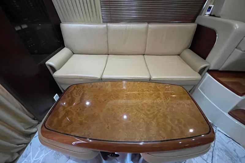 Beira Mar Yacht Photos Pics Luxurious interior of 2005 Sea Ray 420 Sedan Bridge with leather sofa and polished wood table.