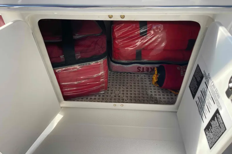 Beira Mar Yacht Photos Pics Storage compartment on 2005 Sea Ray 420 Sedan Bridge with red bags and safety equipment.