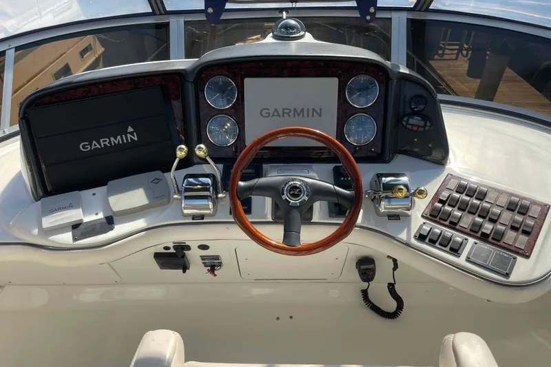 Beira Mar Yacht Photos Pics 2005 Sea Ray 420 Sedan Bridge helm with Garmin navigation system and wood-trimmed steering wheel.
